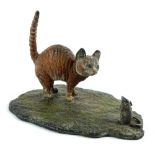 An Austrian style cold painted bronze figure of a ginger cat with a mouse, on a shaped base,