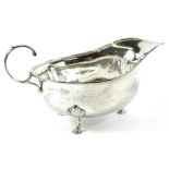 A George V silver sauce boat, of cape form, with 'c' scroll handle, on triple hoof supports,