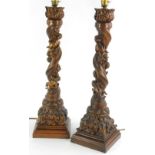 A pair of late 19th/early 20thC carved Italian lamp bases, each decorated with three putti on a