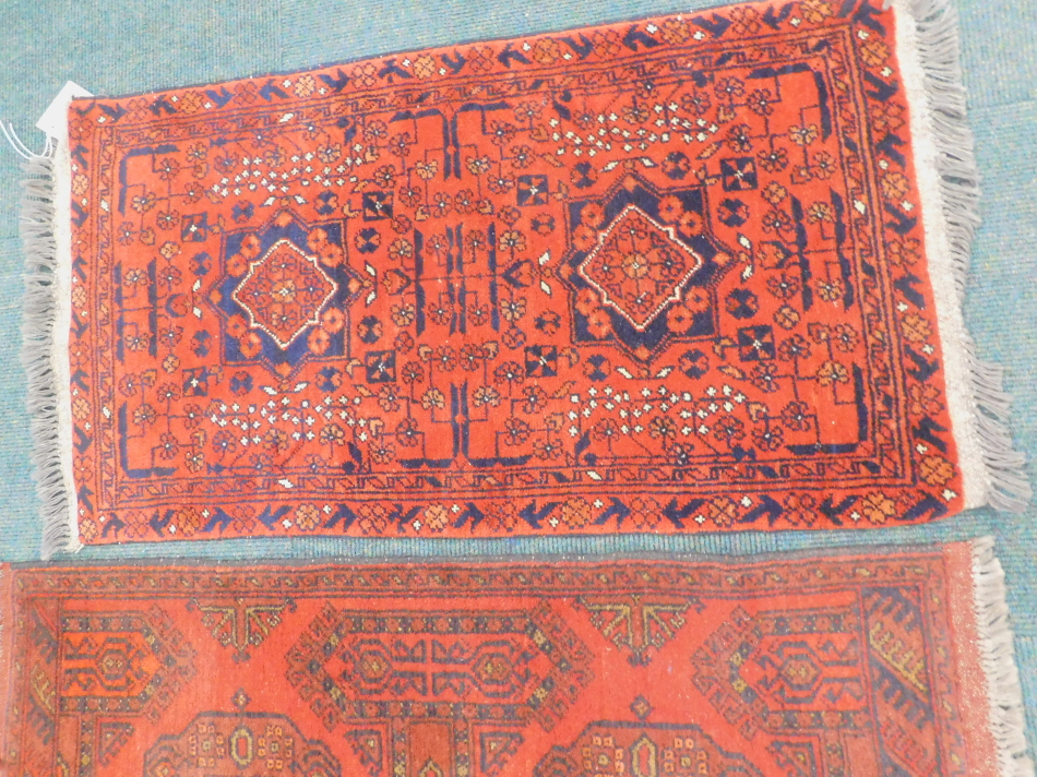 Two Turkish design small rugs, each with a design of medallions on a red ground, 94cm x 54cm and - Image 3 of 4