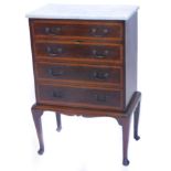 An Edwardian mahogany and satinwood cross banded music cabinet, with a white marble top, with four