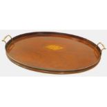 An early 20thC mahogany oval galleried tray, with two brass handles and central shell inlay, 60cm