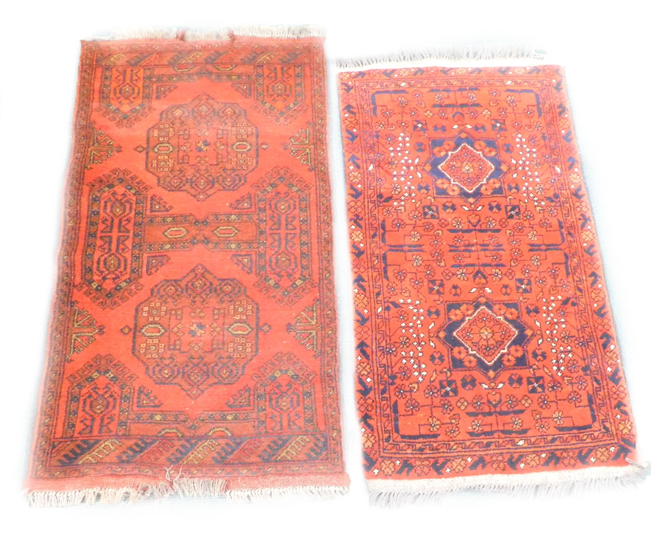 Two Turkish design small rugs, each with a design of medallions on a red ground, 94cm x 54cm and