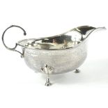 A George V silver sauce boat, of cape form, with 'c' scroll handle, on triple hoof supports,