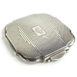 An Edward VIII Art Deco silver powder compact, the hinged lid enclosing a mirror and a brass