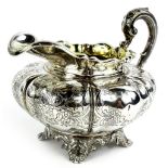 A Victorian silver milk jug, of squat melon form, engraved with scrolls etc and with gilt interior