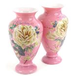 A pair of Victorian pink opaque glass vases, each painted with flowers in coloured enamels, 30cm H.