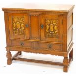 An oak side cabinet, the rectangular top with a moulded edge above two doors, each carved with a