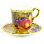 A Royal Worcester porcelain cup and saucer, decorated with fruit by Freeman, printed mark in black