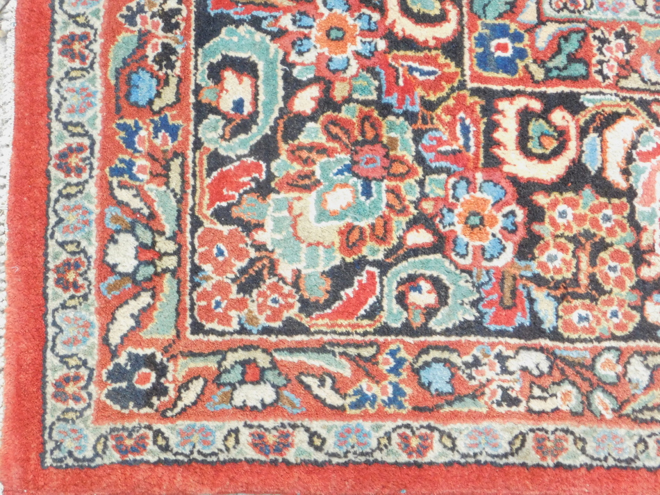 A Persian Meshed type carpet, with a design of flowers on a red ground with multiple borders, - Image 2 of 3