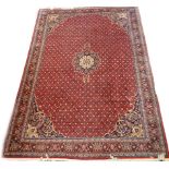 WITHDRAWN PRIOR TO SALE. A Persian Meshed type carpet, with a central navy blue and cream medallion