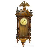 A late 19th/early 20thC walnut Vienna type wall clock, with a composite gilt eagle to the shaped