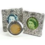 A pair of sterling silver photograph frames, each with shaped square form repousse decoration with