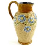 A Doulton Lambeth stoneware jug, decorated with blue flowers on a sculpted ground, impressed marks