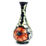 A Moorcroft pottery bottle shaped vase, decorated with a design of poppies, various impressed
