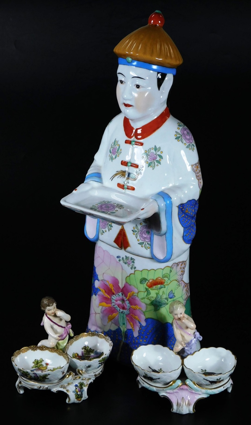A Chinese figure group, of a gentleman in flowing robes holding dish, florally polychrome
