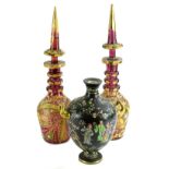 A pair of Bohemian style ruby tinted decanters, each with a Middle Eastern style coloured enamel