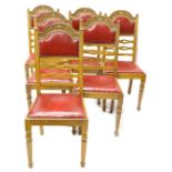 A set of six early 20thC oak dining chairs, each with a carved back, a red leatherette padded back