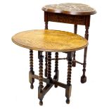 An early 20thC carved oak occasional table, the trefoil shaped top decorated with flowers, leaves