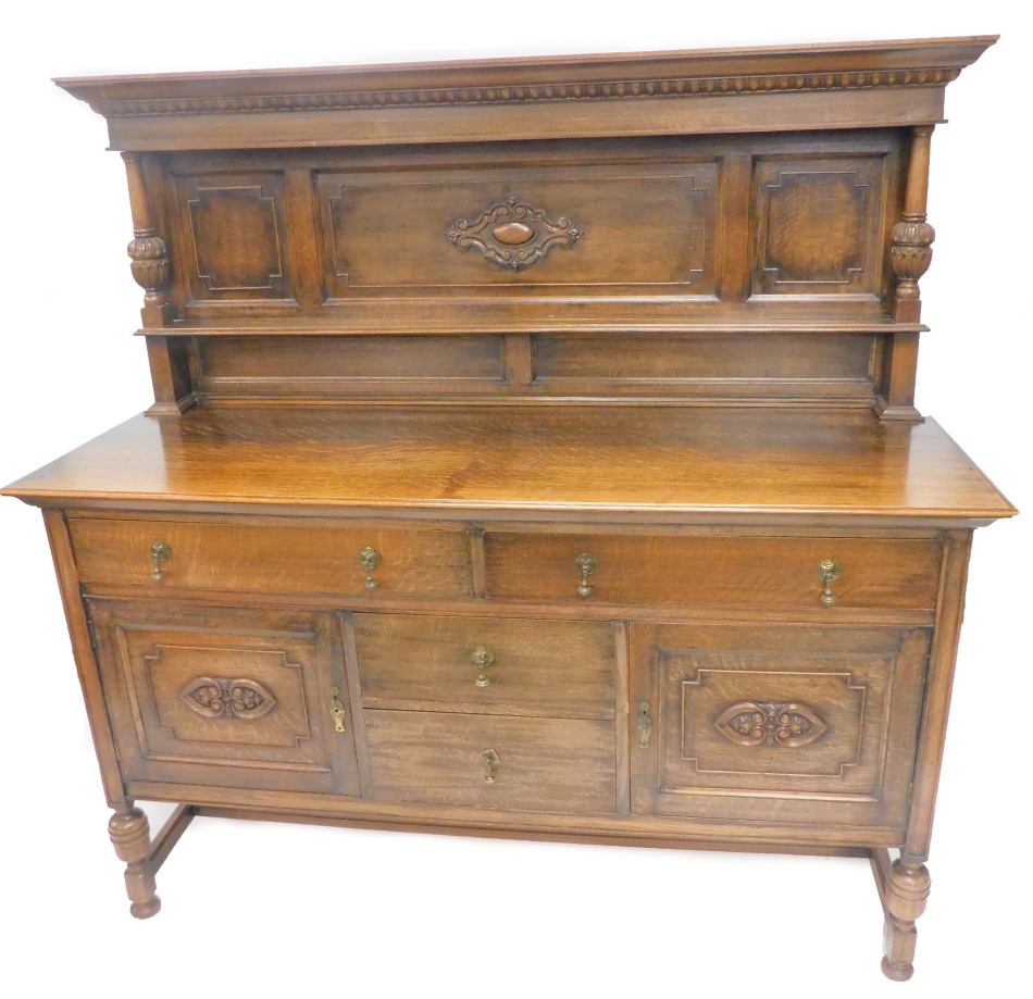 A 20thC oak sideboard, the raised back with a moulded and gadrooned cornice, above a panel front