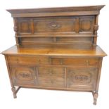 A 20thC oak sideboard, the raised back with a moulded and gadrooned cornice, above a panel front