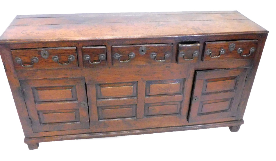 An 18thC oak dresser base, the rectangular planked top with a moulded edge above an arrangement of