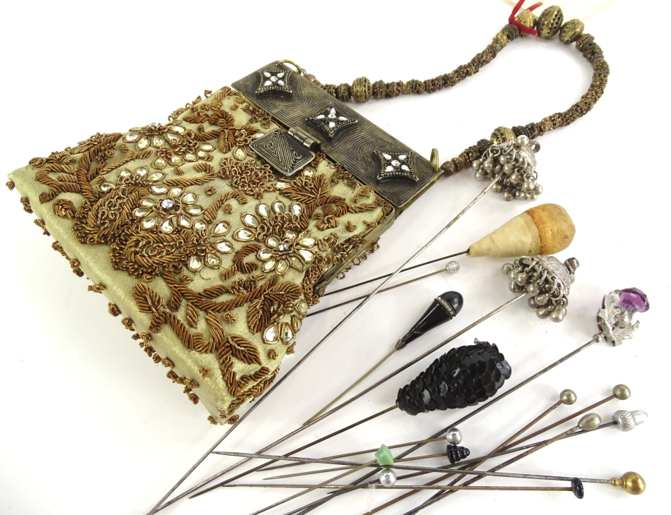 A quantity of hat pins, of varying design on stainless steel pins, and a beaded evening purse with