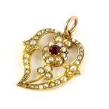 An Art Nouveau pendant, set with seed pearls and garnet stone, on yellow metal pendant back,