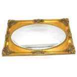 A gilt rectangular wall mirror, with an oval bevel plate, 75cm x 150cm.