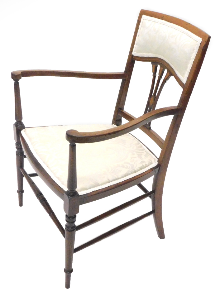 An Edwardian mahogany open armchair, with a padded back and seat, pierced splat and turned legs with