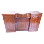 A Victorian mahogany sideboard, the moulded edge above a central serpentine shaped drawer, above a