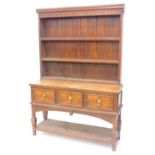 A 20thC oak dresser, the raised back with three plate shelves, the base with three panelled frieze