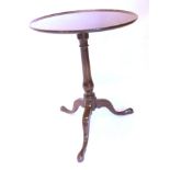 A George III mahogany occasional table, the circular dished tilting top with a turned column and