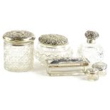 A collection of cut glass scent bottles, each with silver covers etc.