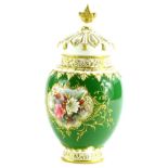 A Royal Worcester porcelain pot pourri jar cover, painted with a flower spray, on a green ground