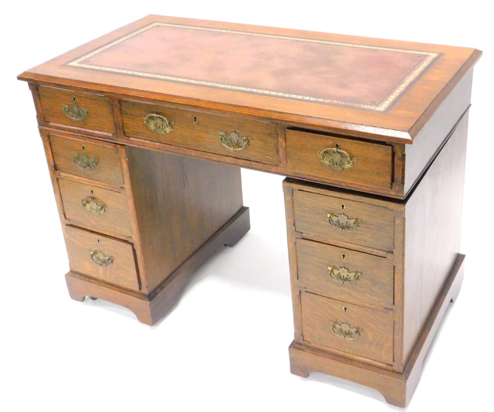 An early 20thC oak pedestal desk, the rectangular top with a later leatherette inset above an