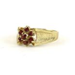 A 9ct gold dress ring, set with garnets, in a floral cluster, ring size T, 1.8g all in.