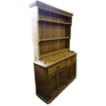 A 19thC and later pine dresser, the plate rack with three shelves, the base with two drawers and two