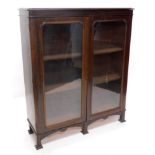 A Victorian mahogany bookcase, the top with a moulded cornice above two glazed doors, enclosing