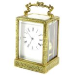 A late 19thC French brass carriage clock, elaborately engraved with foliate scrolls etc., with a