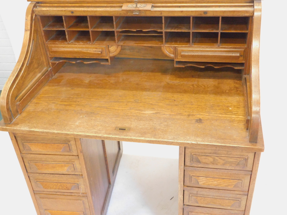 An early 20thC oak roll top desk, the tambour front enclosing a fitted interior above four drawers - Image 2 of 2