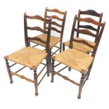 An associated set of four 19thC country made oak and ash ladder back chairs, each with a rush seat