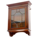 An Edwardian mahogany wall cabinet, with a moulded cornice above a single astragal glaze door,