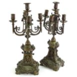 A pair of French brass five branch candelabra, each cast with masks, scrolls, lions heads etc., 52cm