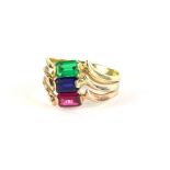 A three row dress ring, set with three baguette cut stones, emerald, ruby and sapphire, with wave