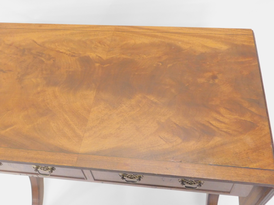 A mahogany sofa table in Regency style, the rectangular quarter veneered top with a cross banded and - Image 2 of 2