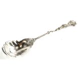 A late 19th/early 20thC continental silver serving spoon, the handle cast with a figure, a fleur