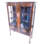 An Edwardian mahogany display cabinet, the moulded cornice above two glazed bow fronted doors,