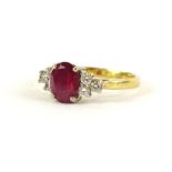 An 18ct gold ruby and diamond ring, with oval cut ruby in claw setting, flanked by three tiered