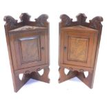 A pair of late Victorian walnut and figured walnut corner stands, each with a single door, adapted